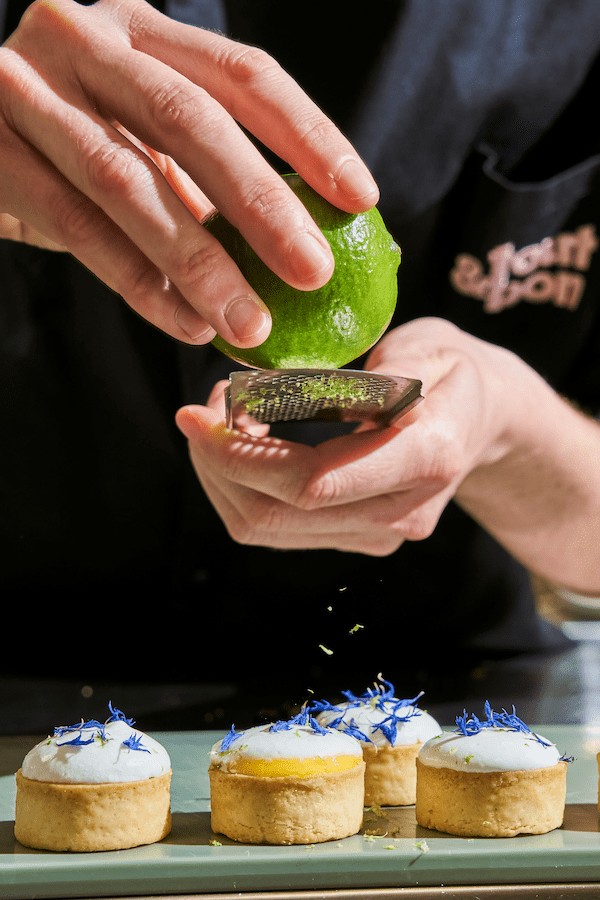 Gros plan sur un chef zestant un citron vert