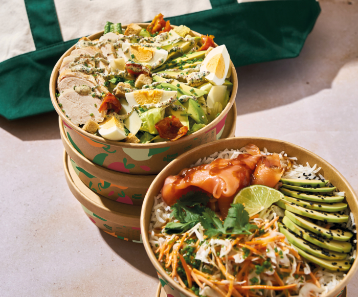 Mains tenant des bols en carton avec salades